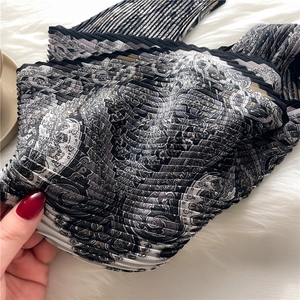 Élégant foulard en soie plissé avec motif paisley sur un fond en peluche blanche