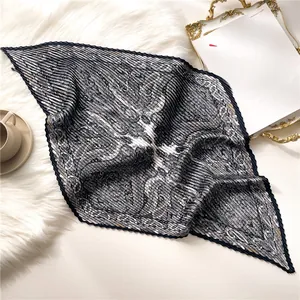 Détail d'un foulard plissé à motif cachemire gris avec des accessoires élégants