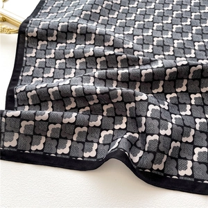 Détail du tissu soyeux avec des motifs à carreaux floraux noirs et blancs et texture