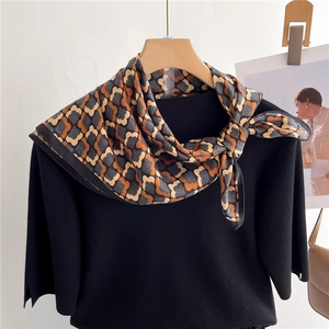 Foulard géométrique floral orange et noir en tissu aspect soie sur un haut en tricot chic