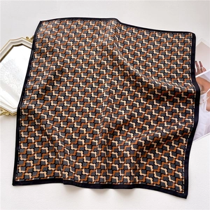 Détail d'un foulard en soie carré avec motifs géométriques vintage et bordure noire