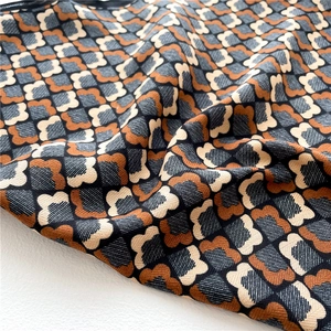 Détail du tissage à chevrons et motif floral sur une écharpe en coton et lin doux