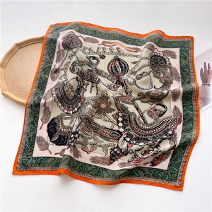 Detail view of luxury silk scarf featuring retro jewelry prints and orange piping trim