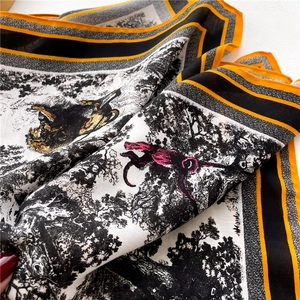 Detail of printed silk scarf with jungle animal pattern and contrasting orange border