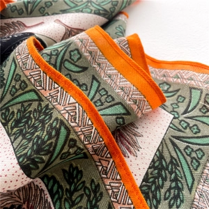Green and orange square silk scarf with tropical leaf pattern and hand-rolled edges