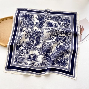Detailed close-up of a blue and white jungle animal print silk square scarf with thick borders