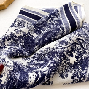 Detail of navy Toile de Jouy jungle pattern on twill silk scarf with striped borders
