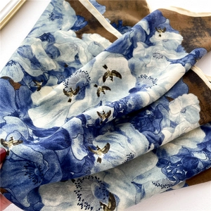 Elegant blue floral silk-feel scarf with golden swallow patterns and white piping