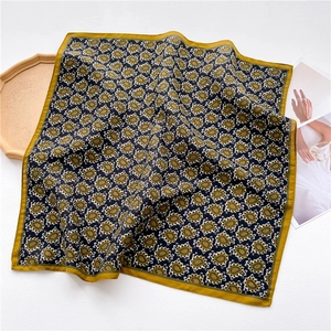Detail of luxury paisley print square scarf with navy and gold ornate pattern