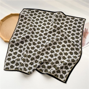 Detail of vintage sunflower paisley silk scarf with black border and premium texture