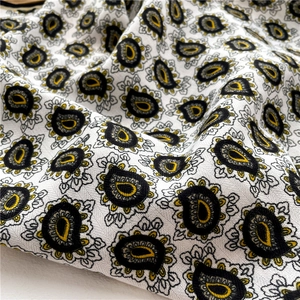 Detailed view of paisley sunflower pattern on soft herringbone textured scarf fabric