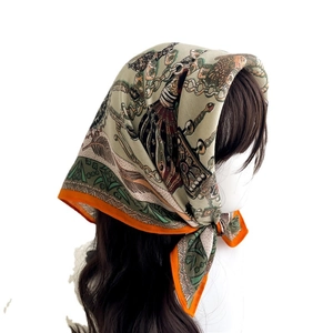Elegant vintage chain print square silk scarf with orange border styled as a headwrap