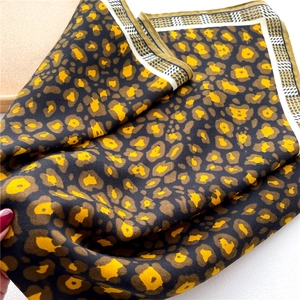 Detail of leopard print silk scarf with black white grid edge and gold hemmed border
