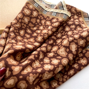 Close-up of leopard print satin scarf with black and white geometric border details