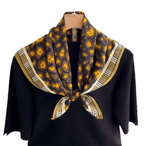 Classic leopard print silk scarf with geometric checkered borders shown on a hanger