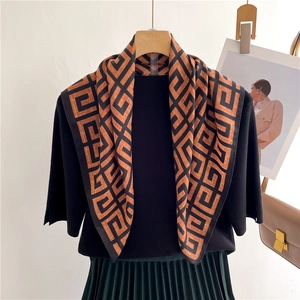 Detail of silk-feel square scarf with Greek Key geometric patterns in orange and black