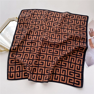 Caramel and black geometric pattern square silk scarf displayed on a beige background