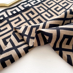 Detail of classic Greek Key pattern on soft woven scarf with black and beige geometric design