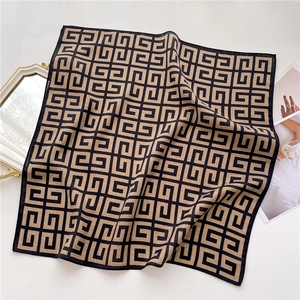 Detail of square scarf with geometric G pattern, khaki silk texture, and chic magazine props