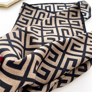 Detail view of beige and black geometric scarf featuring fine twill weave texture