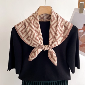 Classic geometric maze print silk scarf for women in beige and brown displayed on a hanger
