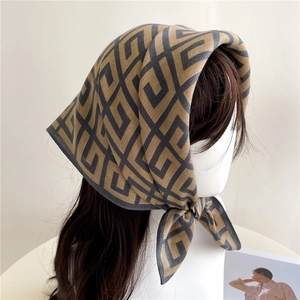 Detail of retro geometric Greek Key pattern on khaki and grey silk-like neck scarf