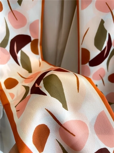 Gros plan d'un foulard en satin avec motifs de feuilles montrant texture et drapé