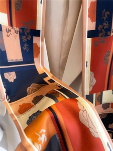 Gros plan d'un foulard ruban en soie avec motifs floraux vintage et géométriques
