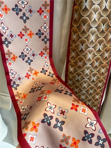 Détail d'un foulard en soie double face avec motif trèfle et texture d'écailles