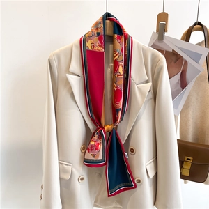 Foulard étroit en soie à imprimé abstrait noué en cravate sur un blazer beige chic