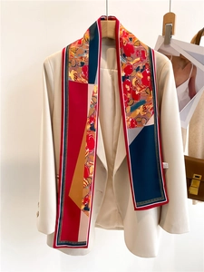 Détail d'un foulard en soie à motifs stylisé sur un blazer beige avec des accessoires