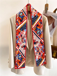 Gros plan d'un foulard artistique en soie sur un blazer beige aux motifs colorés