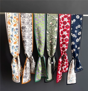 Détails de divers foulards étroits en soie à motifs floraux et géométriques sur un support