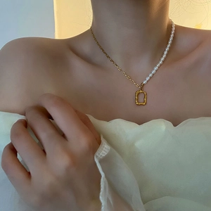 Elegant titanium steel necklace featuring half natural pearls and a geometric gold pendant