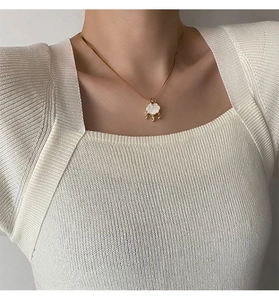 Gros plan d'un collier serrure plaqué or avec incrustation de nacre sur un mannequin
