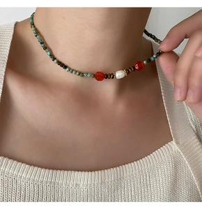 Gros plan d'un collier artisanal avec perles naturelles et perles de turquoise