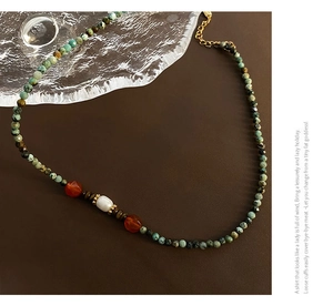 Détail du collier de perles turquoise fait main avec perle blanche et accents d'agate