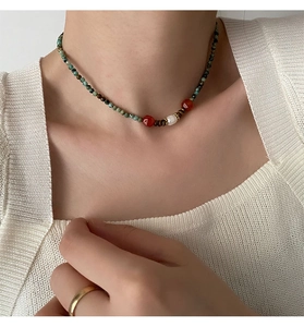 Détail du collier de perles minérales vertes avec une perle d'eau douce naturelle