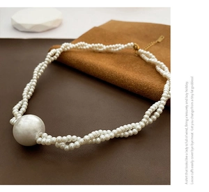 Detailansicht der mehrsträngigen Perlenkette mit großer Muschelperle und Goldverschluss