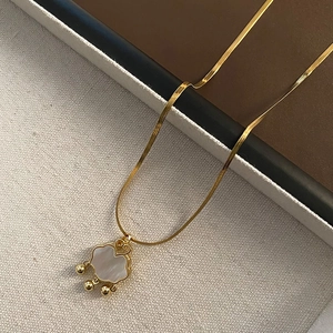 Collana in acciaio al titanio dorato con lucchetto in conchiglia e perline d'oro