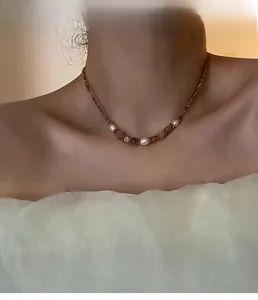 Gros plan d'un collier de perles naturelles et pierres roses porté par un mannequin