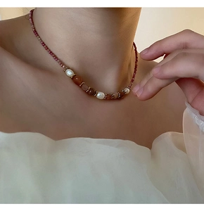 Détail du collier de perles roses et blanches porté sur le cou d'un mannequin