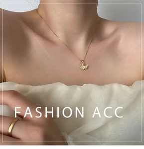 Detail of winged heart necklace with mother of pearl inlay and golden minimalist ring