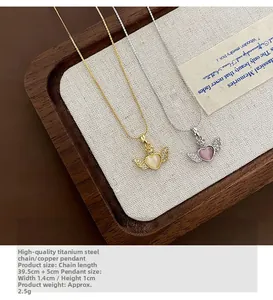 Detail view of heart and wing pendants in gold and silver finish with tiny crystals