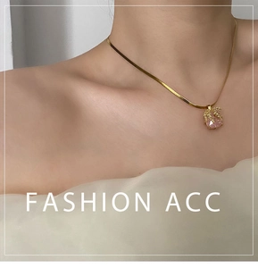 Gros plan d'un collier doré avec pendentif en pierre rose sur le cou d'un mannequin