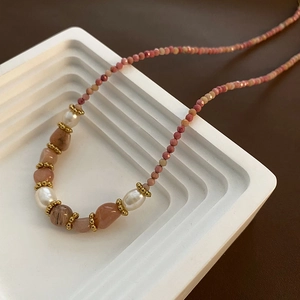 Élégant collier en perles naturelles avec perles roses et accents dorés sur présentoir