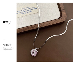 Détail du pendentif en zircone rose avec accents de feuilles argentées sur chaîne serpent