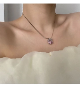 Gros plan du pendentif en zircons roses sur une chaîne serpent portée par un mannequin