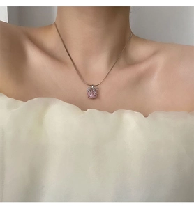 Détail du pendentif pomme en zircon rose sur chaîne serpent porté par un mannequin