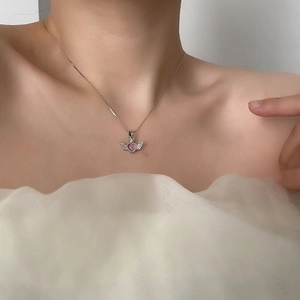 Elegant angel wing necklace with pink heart gemstone on a model's neck for daily wear